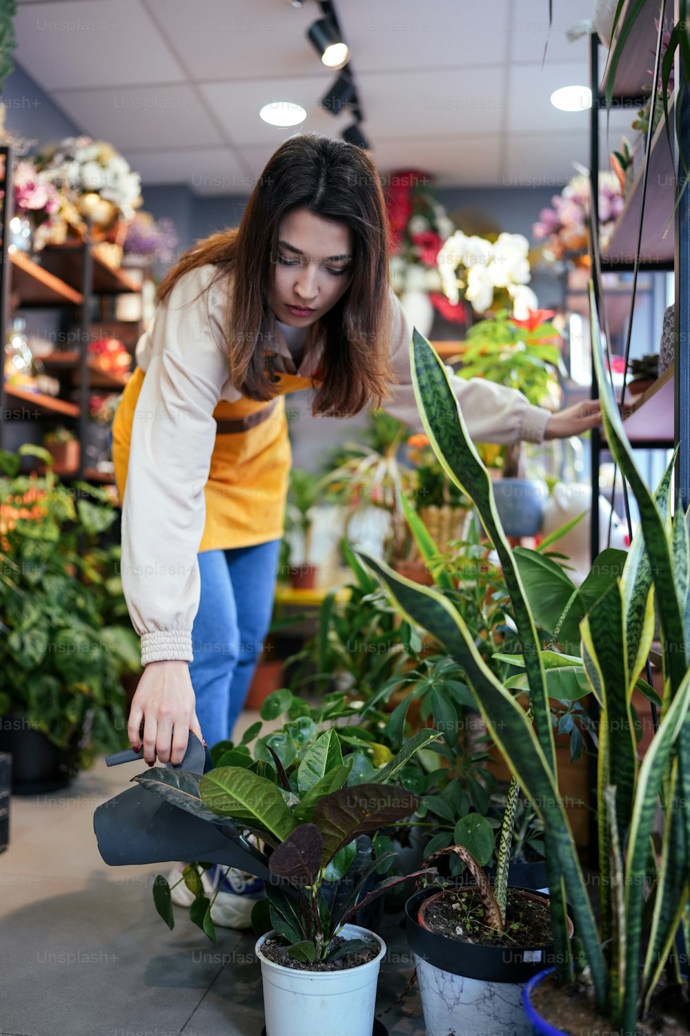 a woman looking at plants in a flower shop