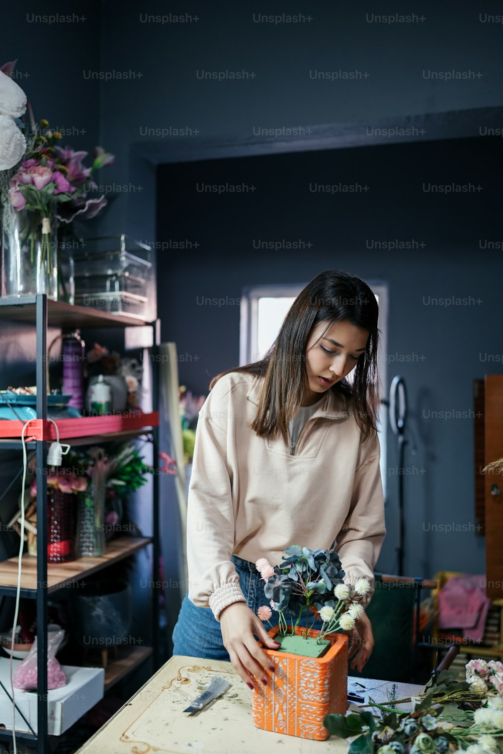 a woman arranging flowers in a flower shop