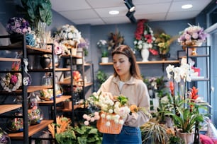 a woman holding a basket of flowers in a flower shop