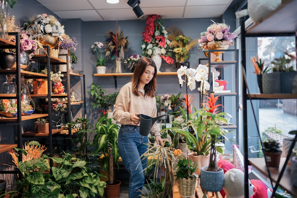 Una mujer de pie en una habitación llena de plantas en macetas