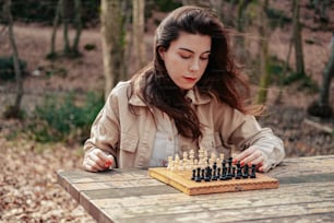 a woman playing a game of chess in the woods