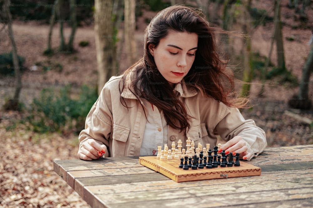 a woman playing a game of chess in the woods