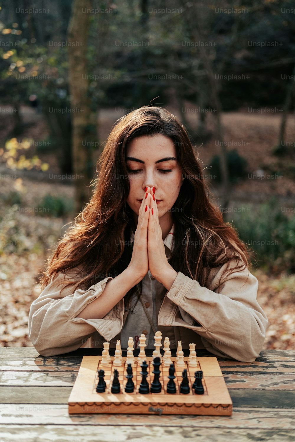 Eine Frau sitzt vor einem Schachbrett