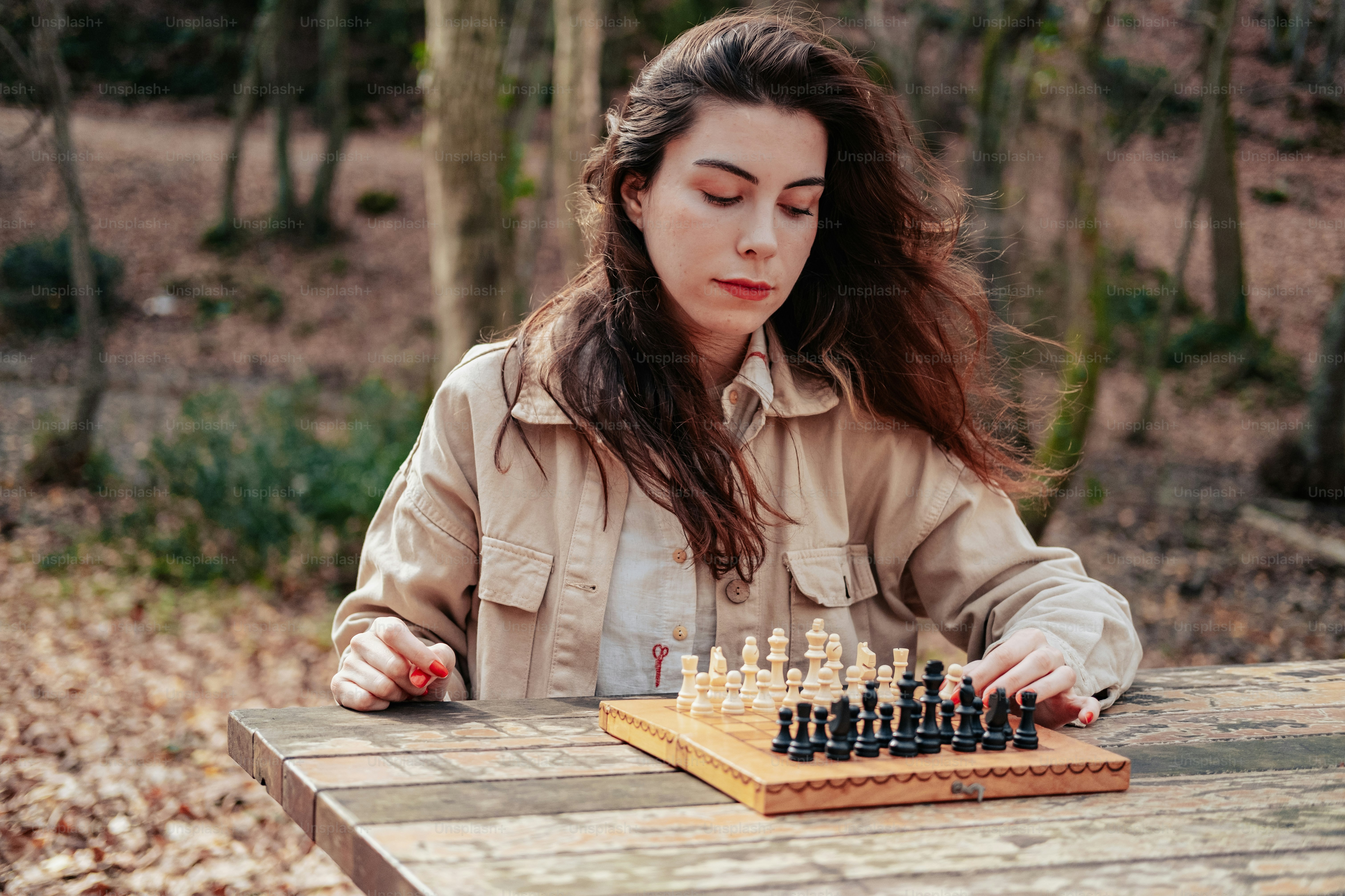 a woman playing a game of chess in the woods