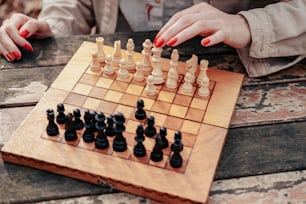 Une femme jouant à une partie d’échecs sur une table en bois