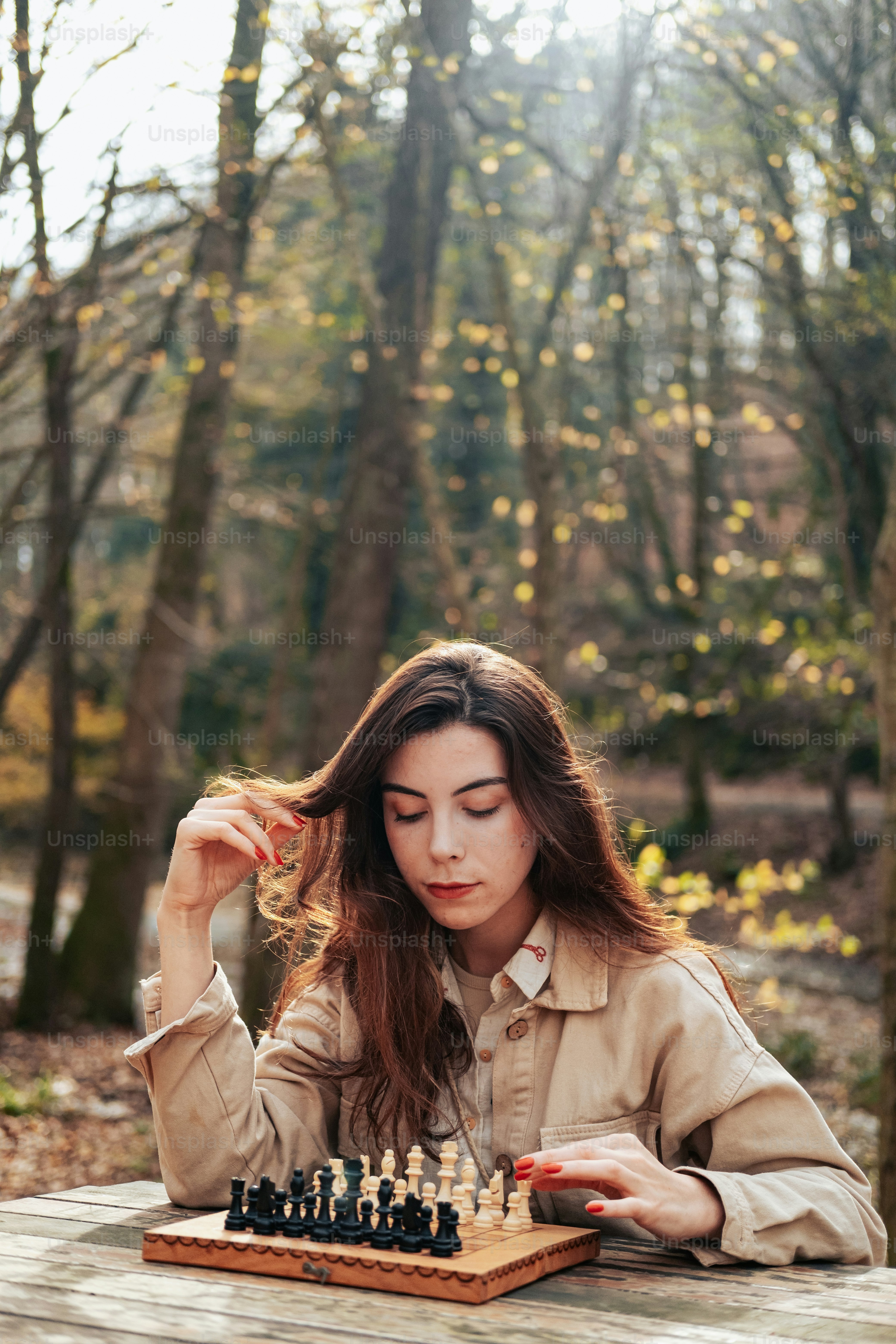 a woman sitting at a table playing a game of chess