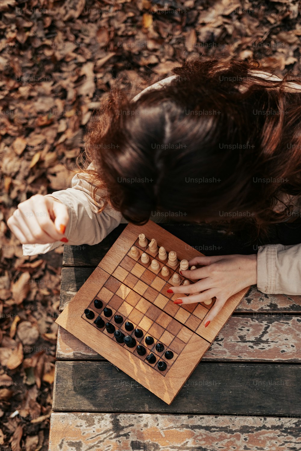 a woman playing a game of checkers on a bench