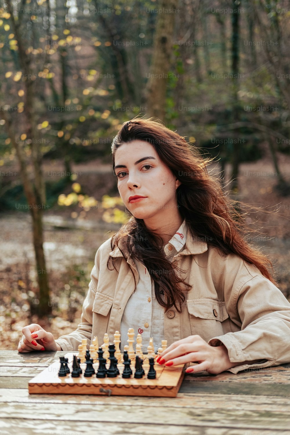 a woman sitting at a table playing a game of chess