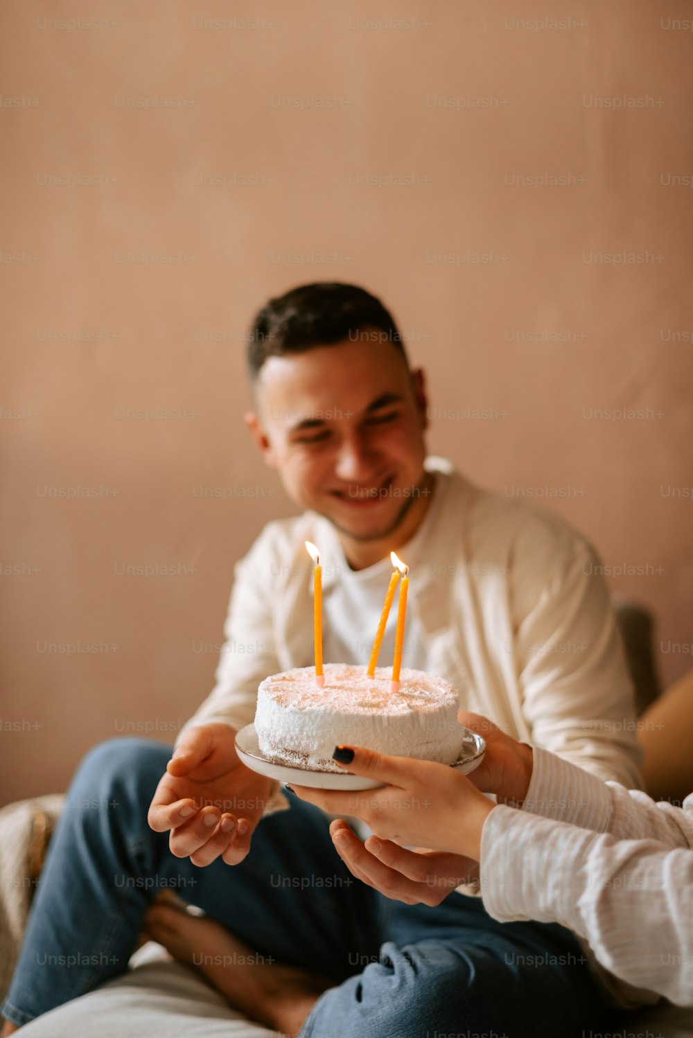 a man holding a cake with candles in it