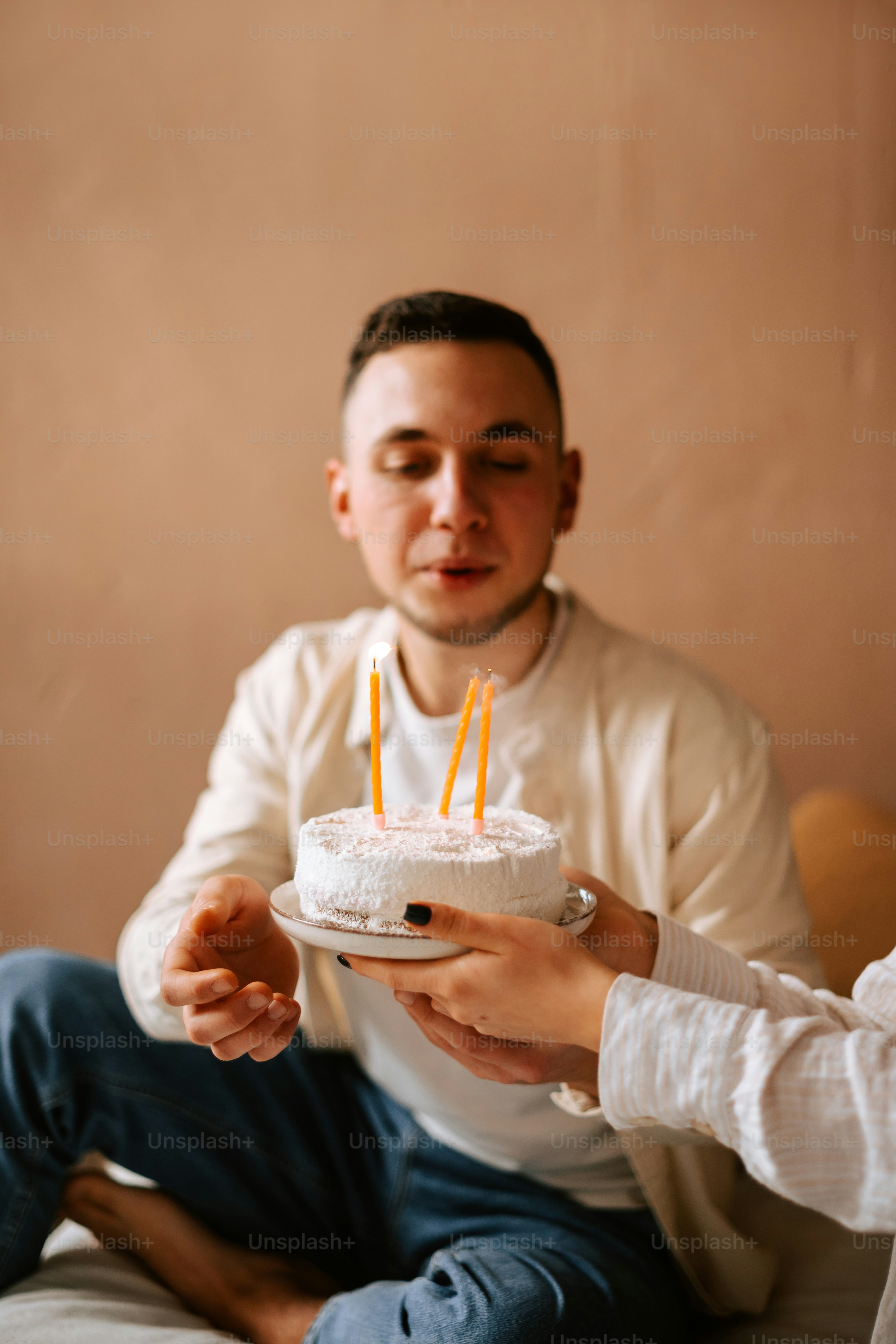 a man holding a cake with candles in it