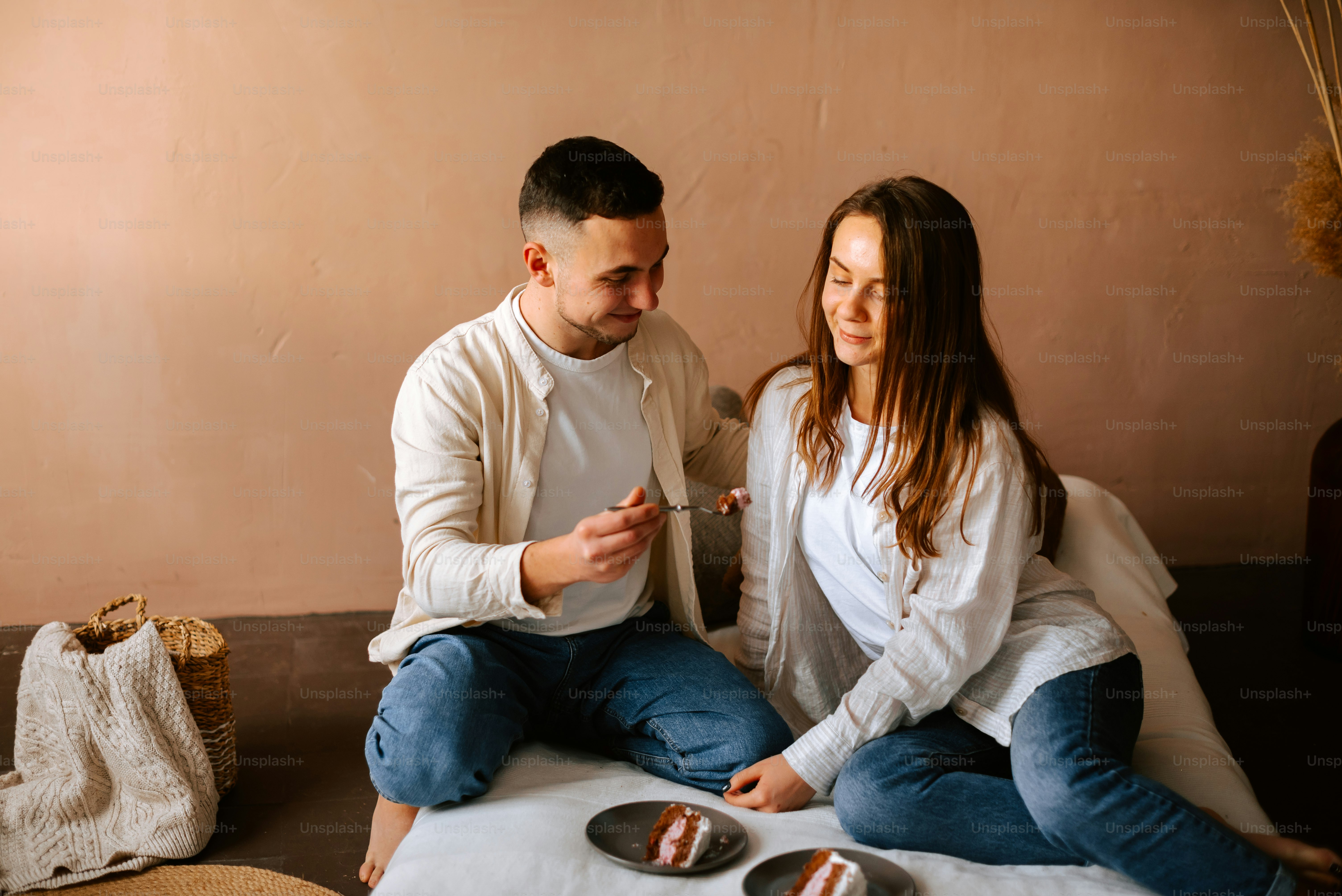 a man and a woman sitting on a bed