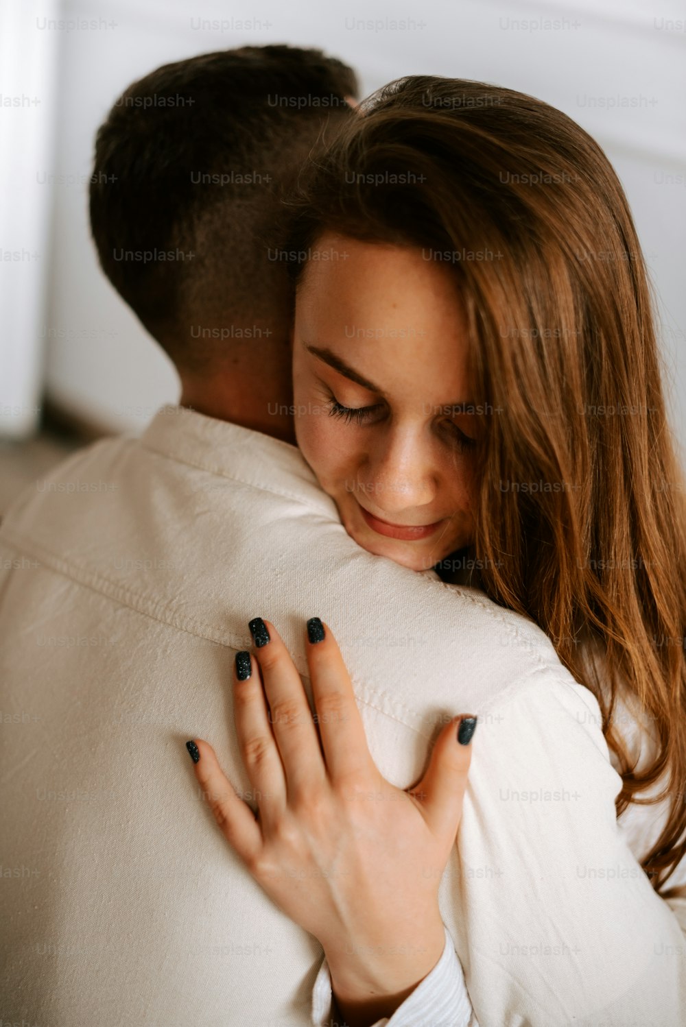 a woman hugging a man in a white shirt