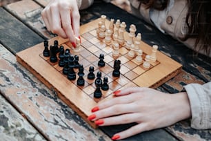 Una mujer jugando una partida de ajedrez sobre una mesa de madera