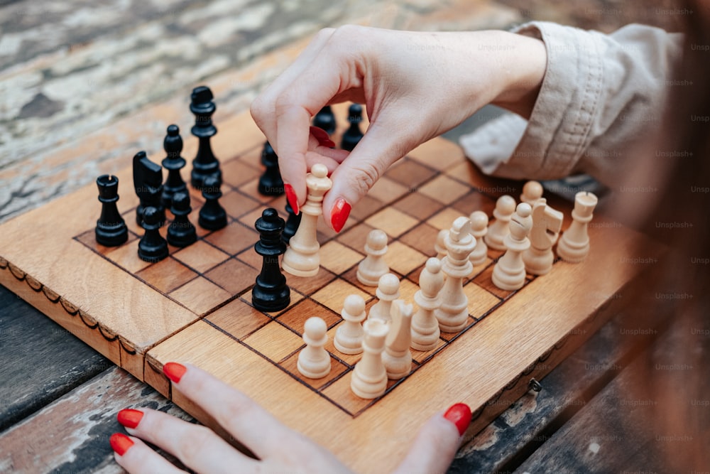 a woman playing a game of chess on a wooden board