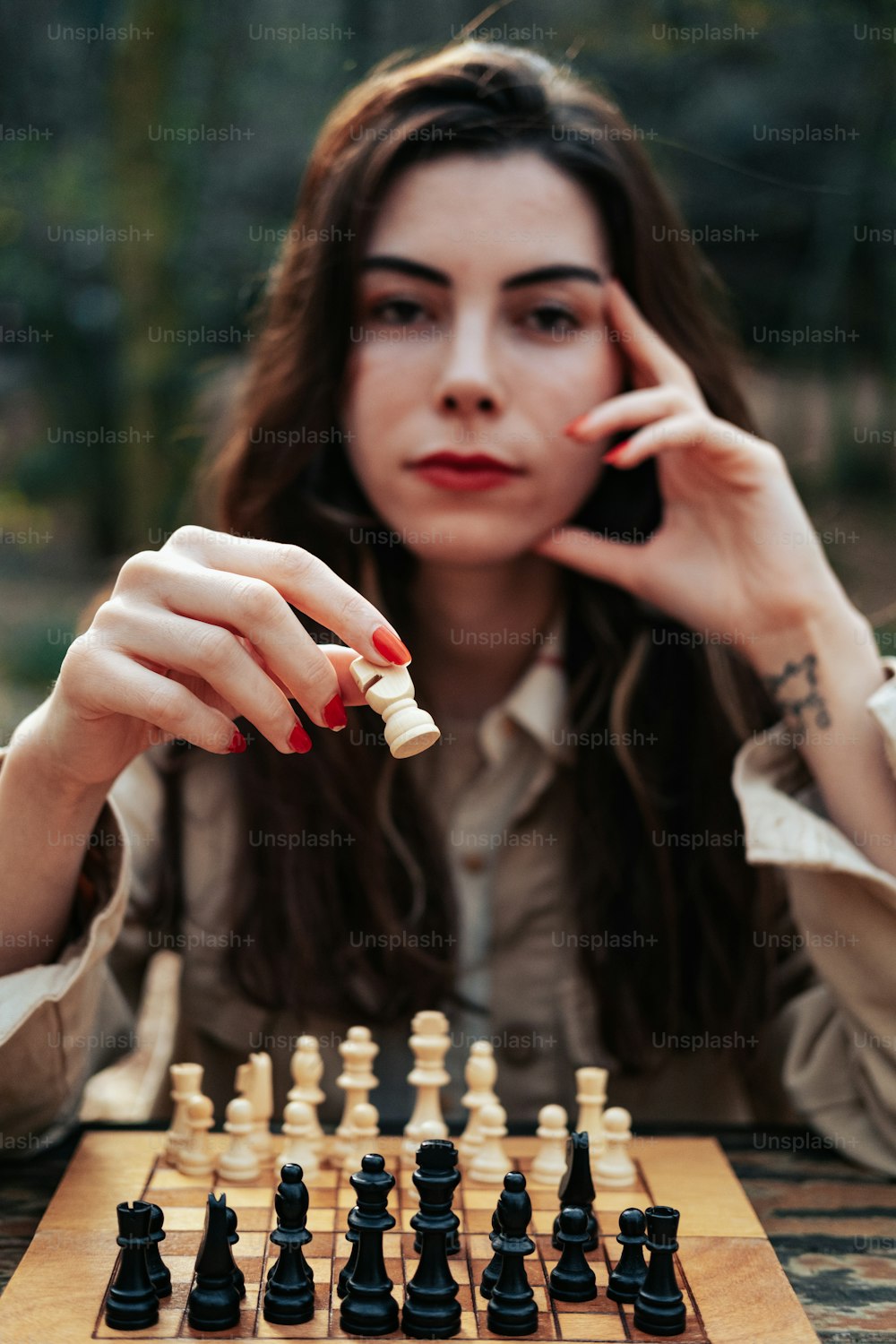 uma mulher sentada em uma mesa com um tabuleiro de xadrez