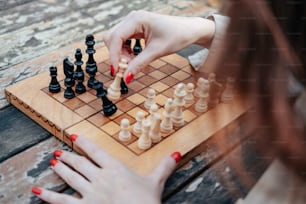 a woman playing a game of chess on a wooden board