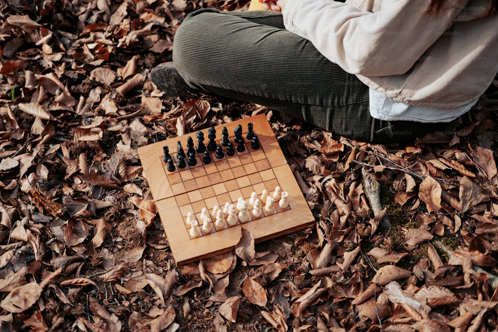 Eine Frau sitzt auf dem Boden und spielt eine Partie Schach