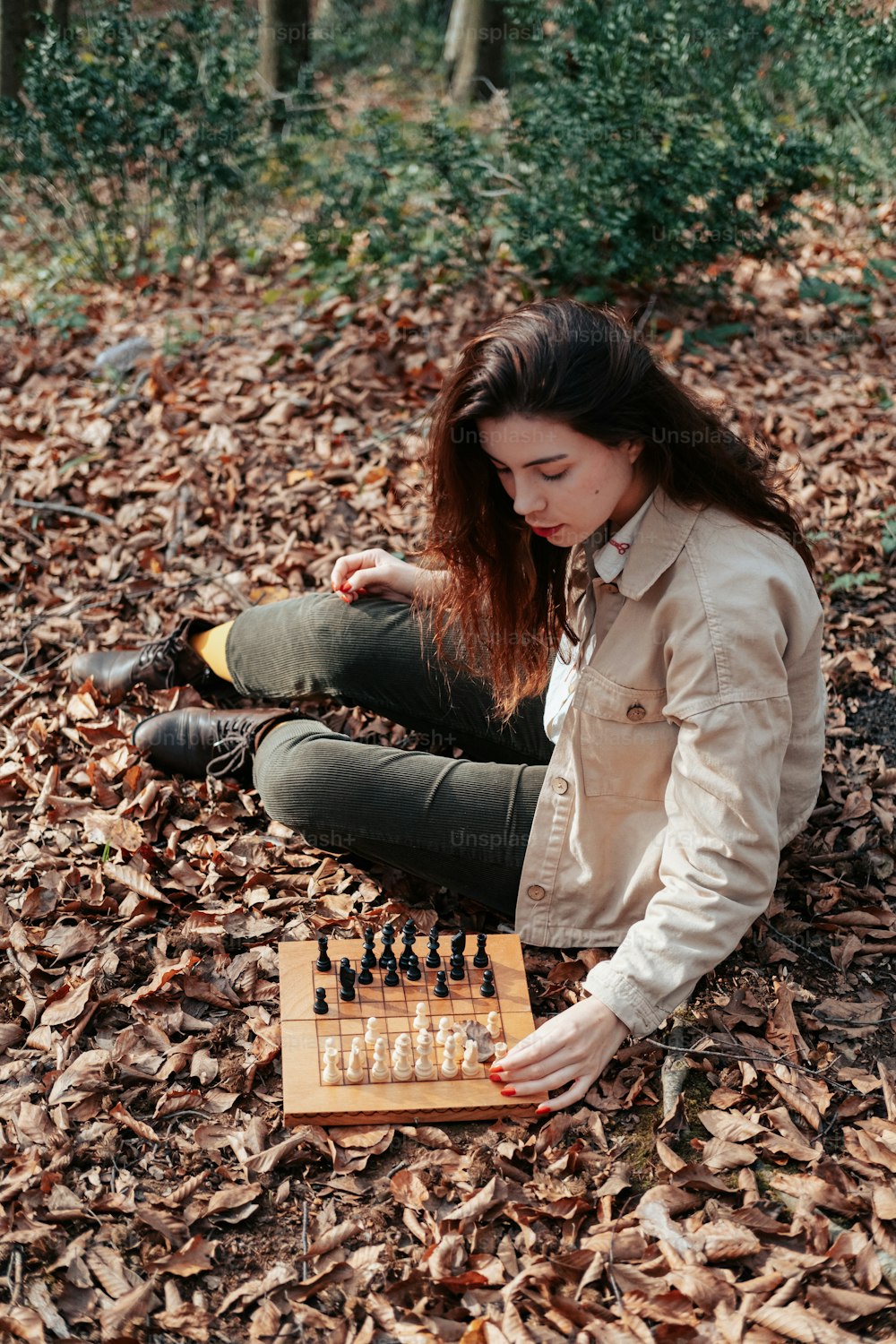 地面に座ってチェスのゲームをしている女性
