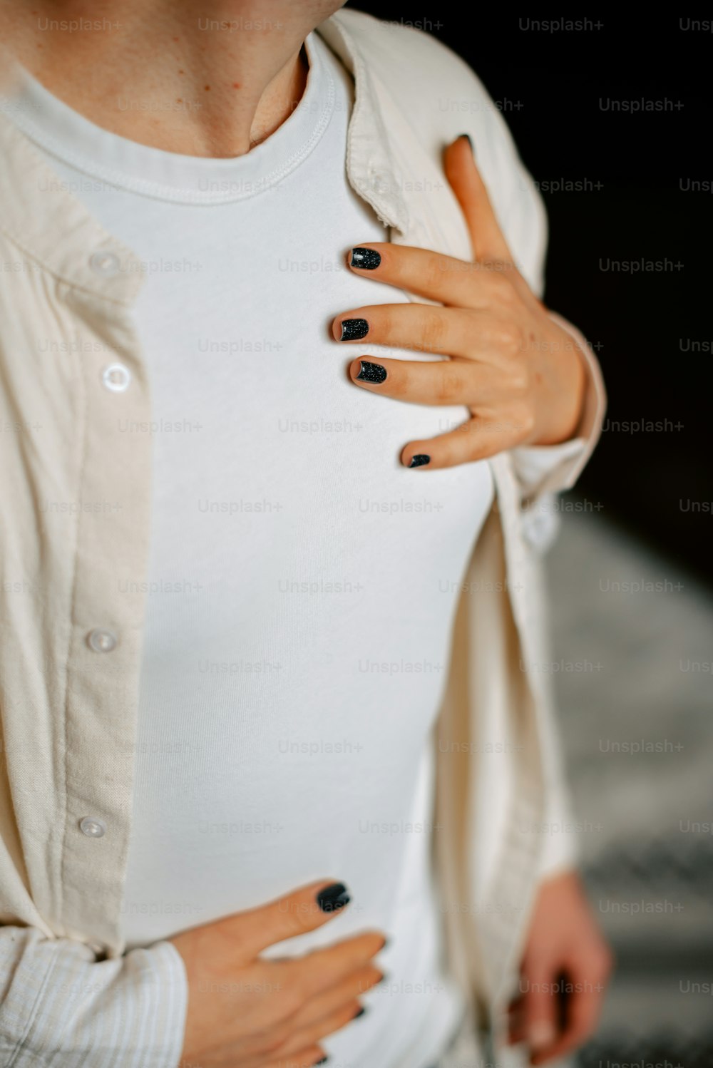a woman with black nails and a white shirt