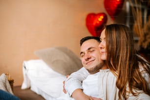 Un homme et une femme se blottissent sur un lit
