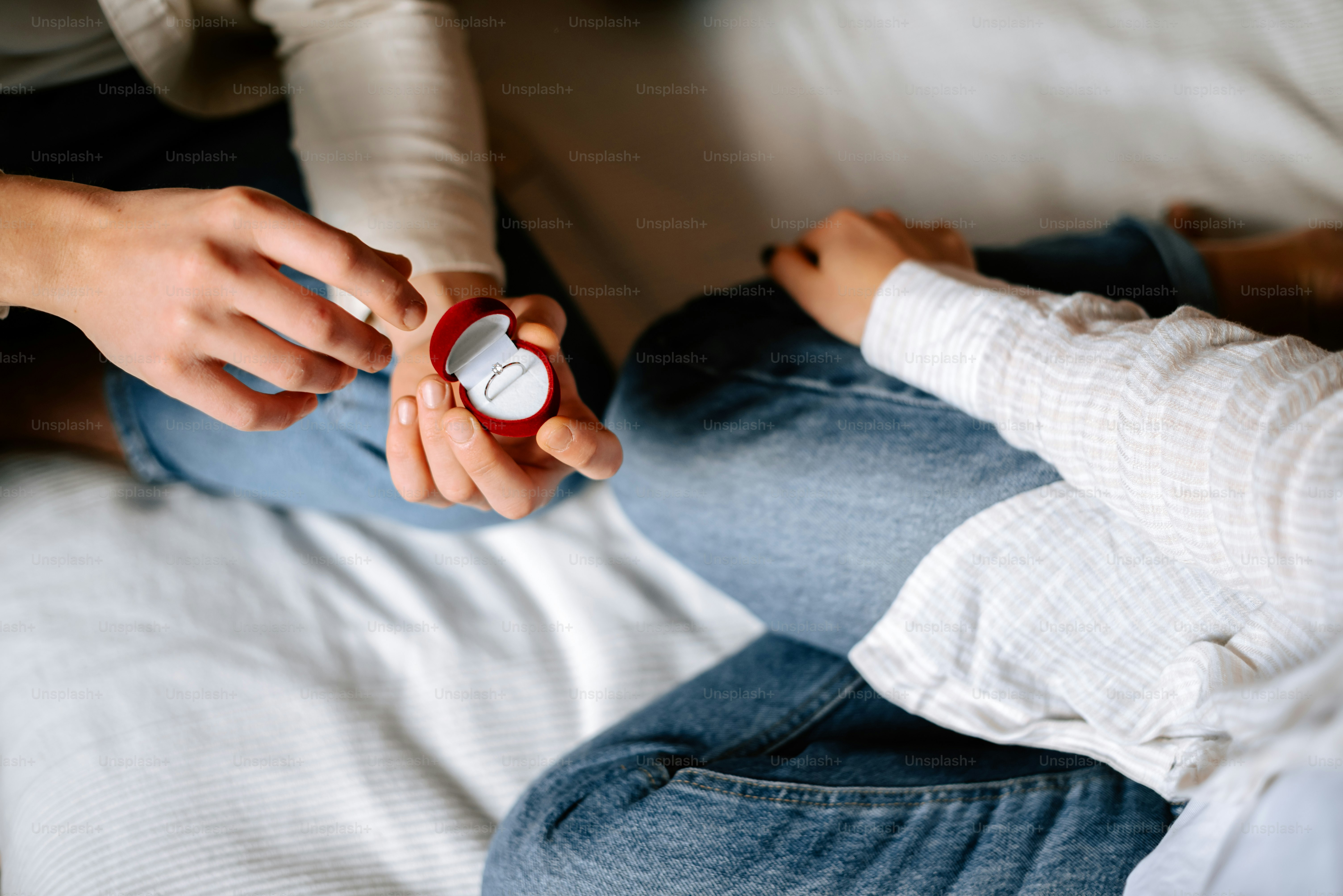 a person sitting on a bed holding a bottle