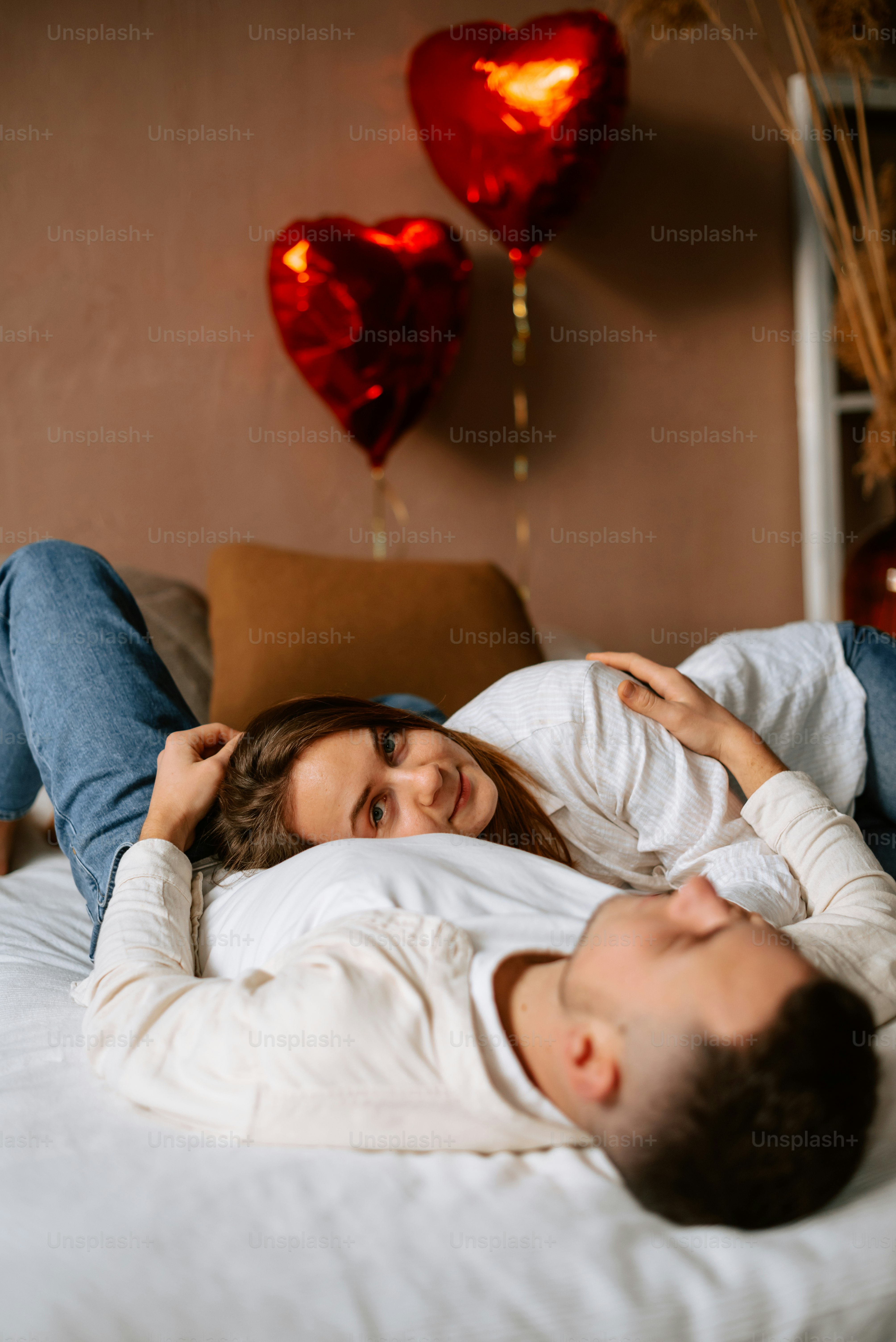 a man and a woman laying on a bed