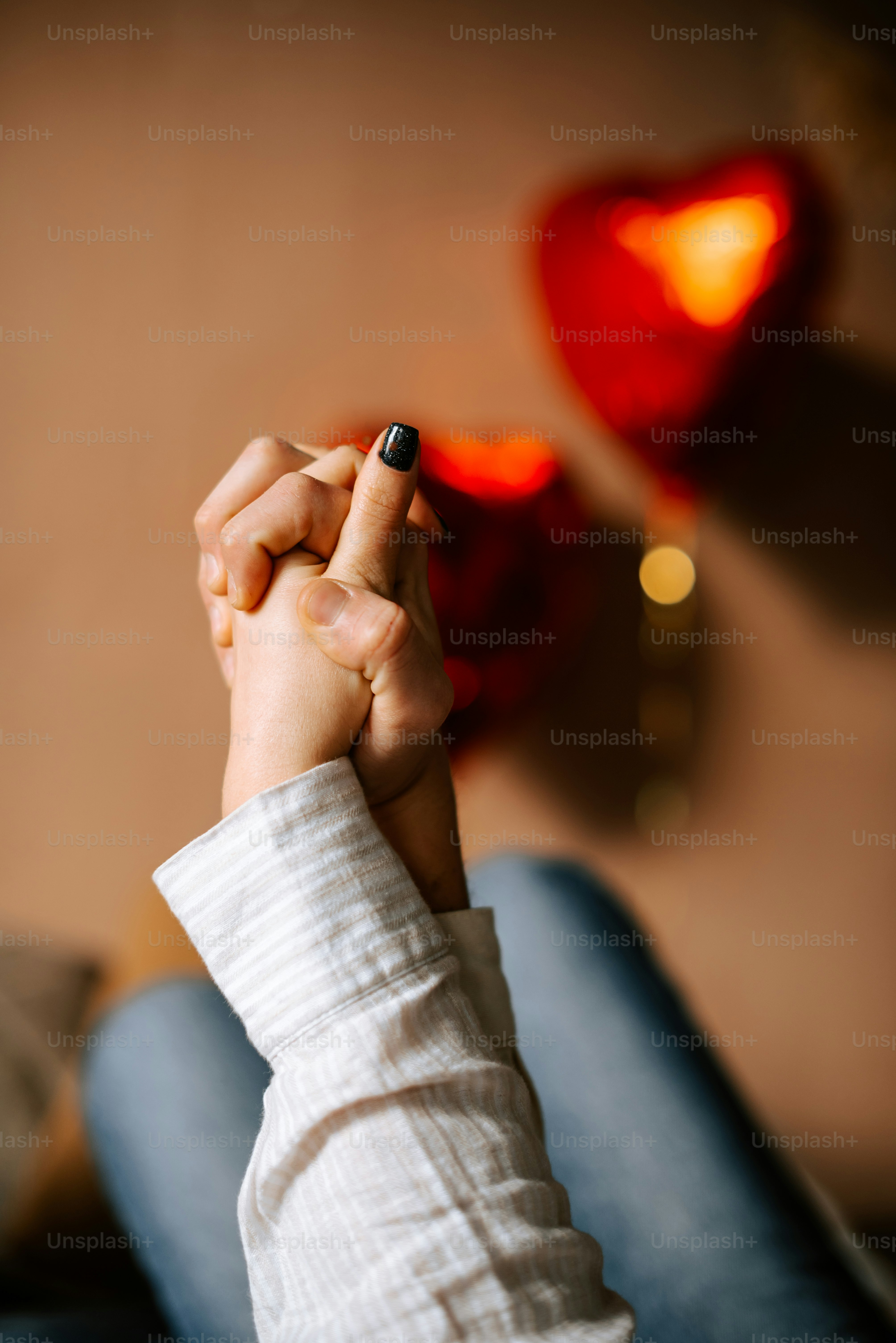 two people holding hands while sitting on a couch