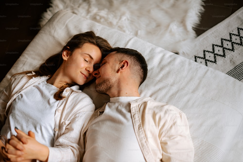 a man and a woman laying on a bed together