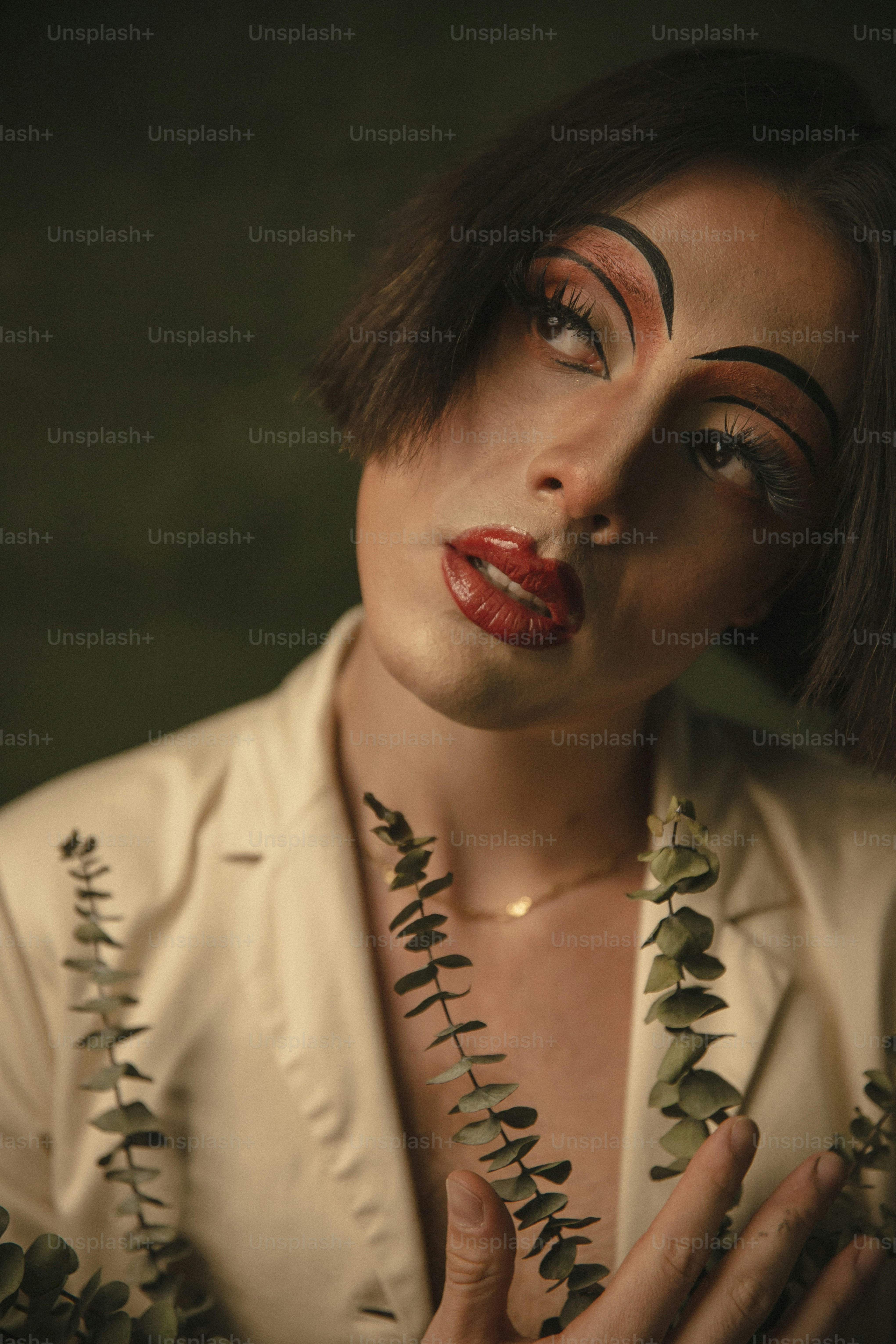 a woman with makeup and leaves on her face