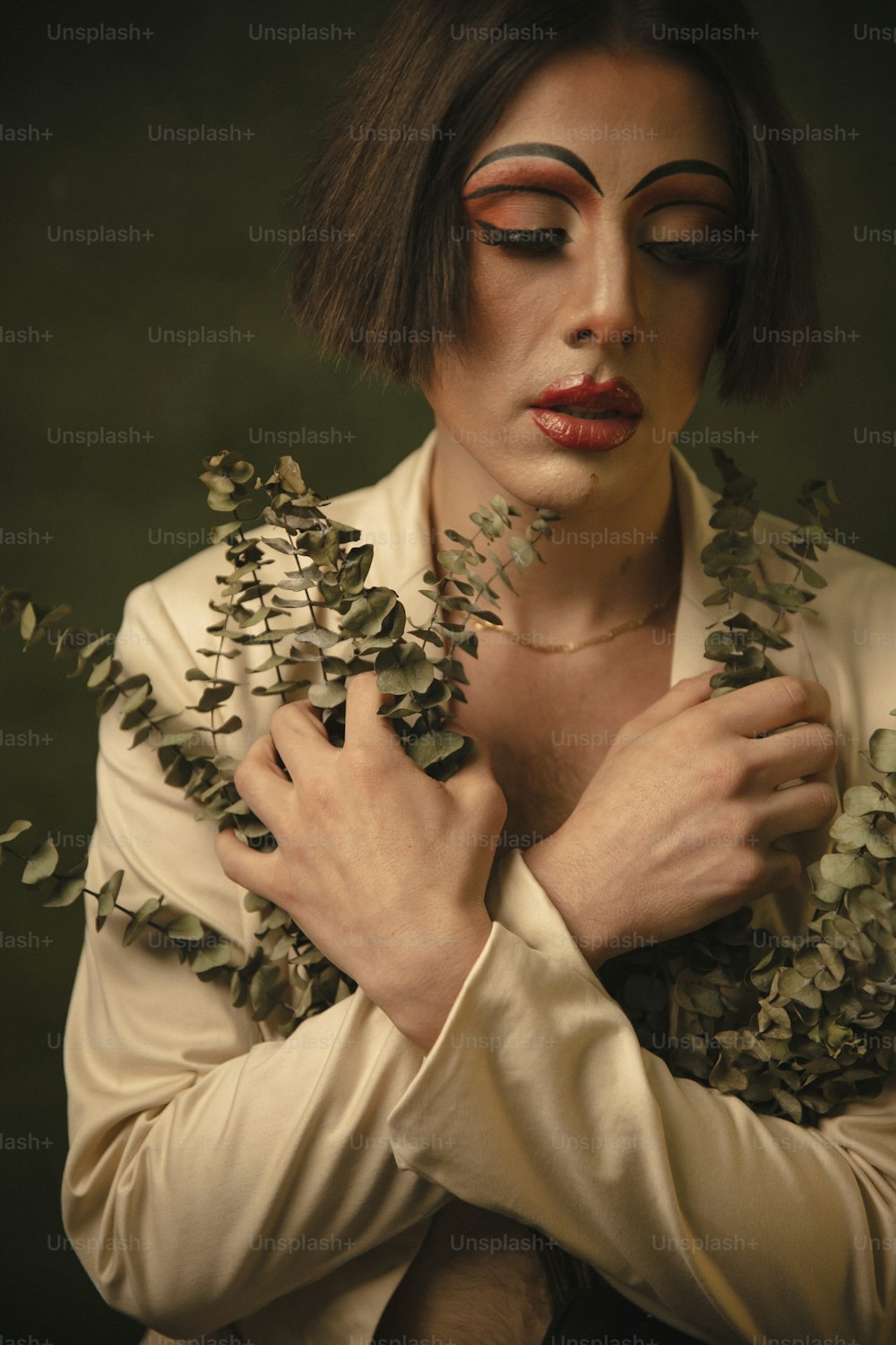 uma mulher com maquiagem e folhas ao redor do pescoço