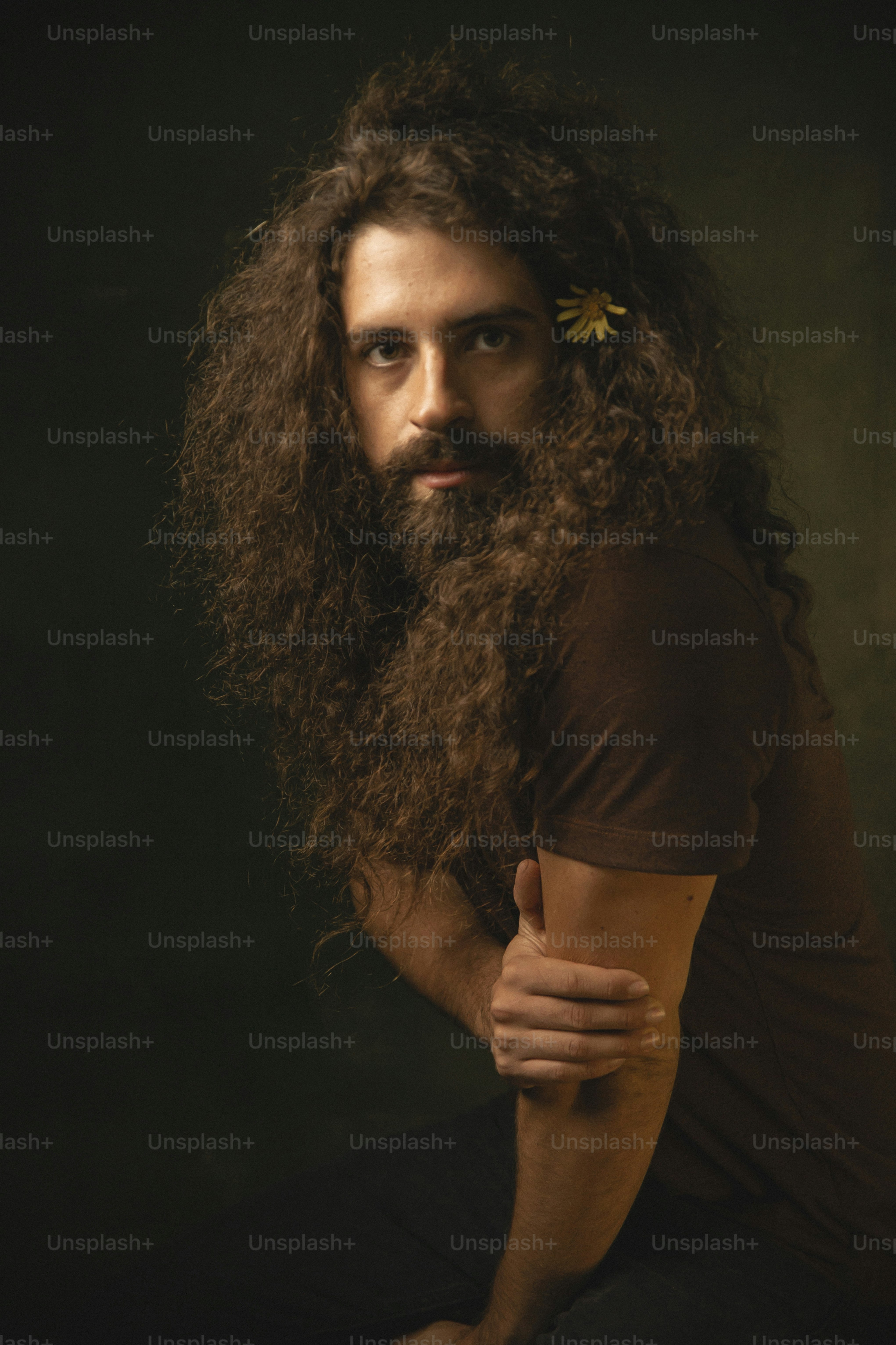 Ein Mann mit langem Bart und einer Blume im Haar