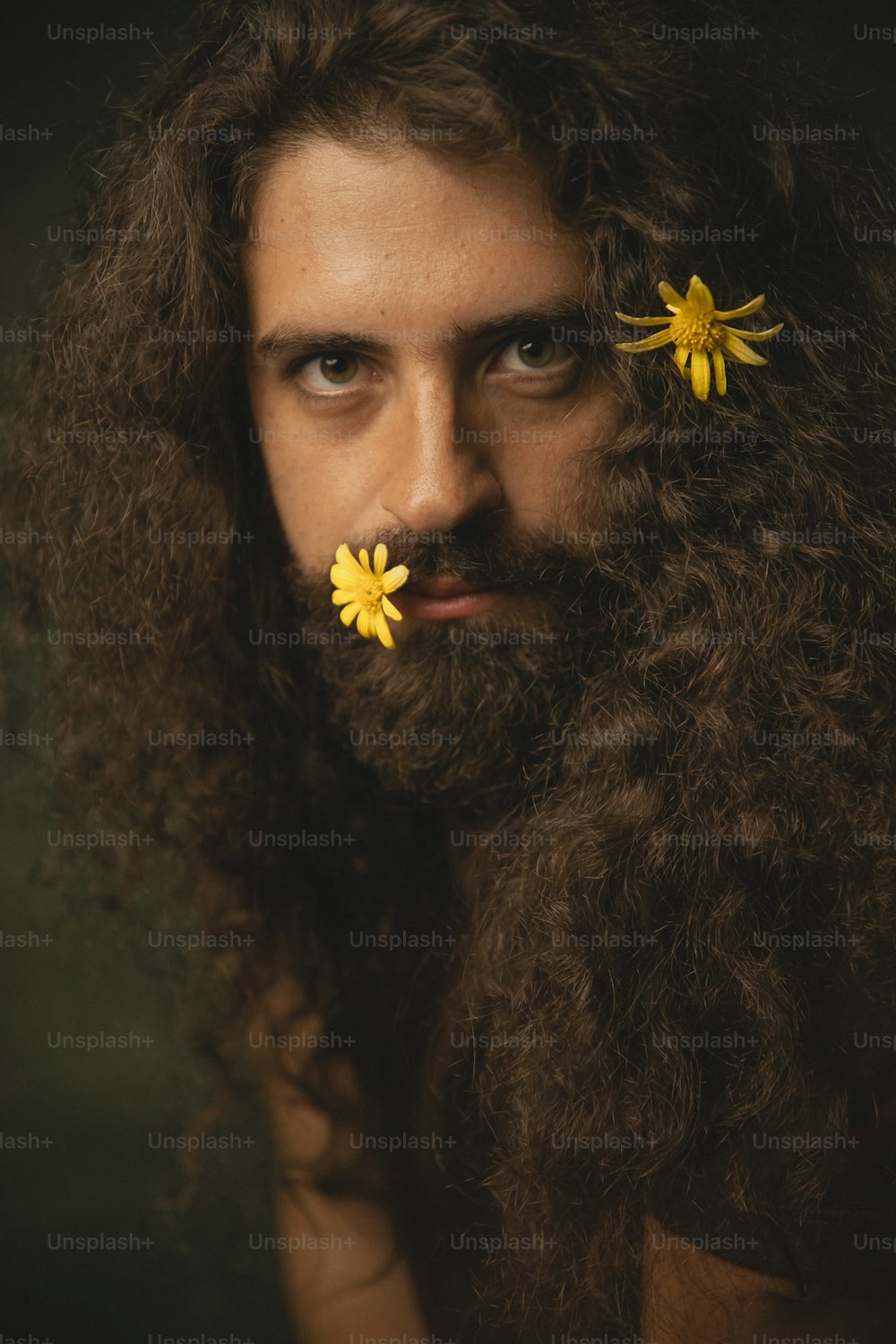 um homem com longos cabelos encaracolados e uma flor na barba