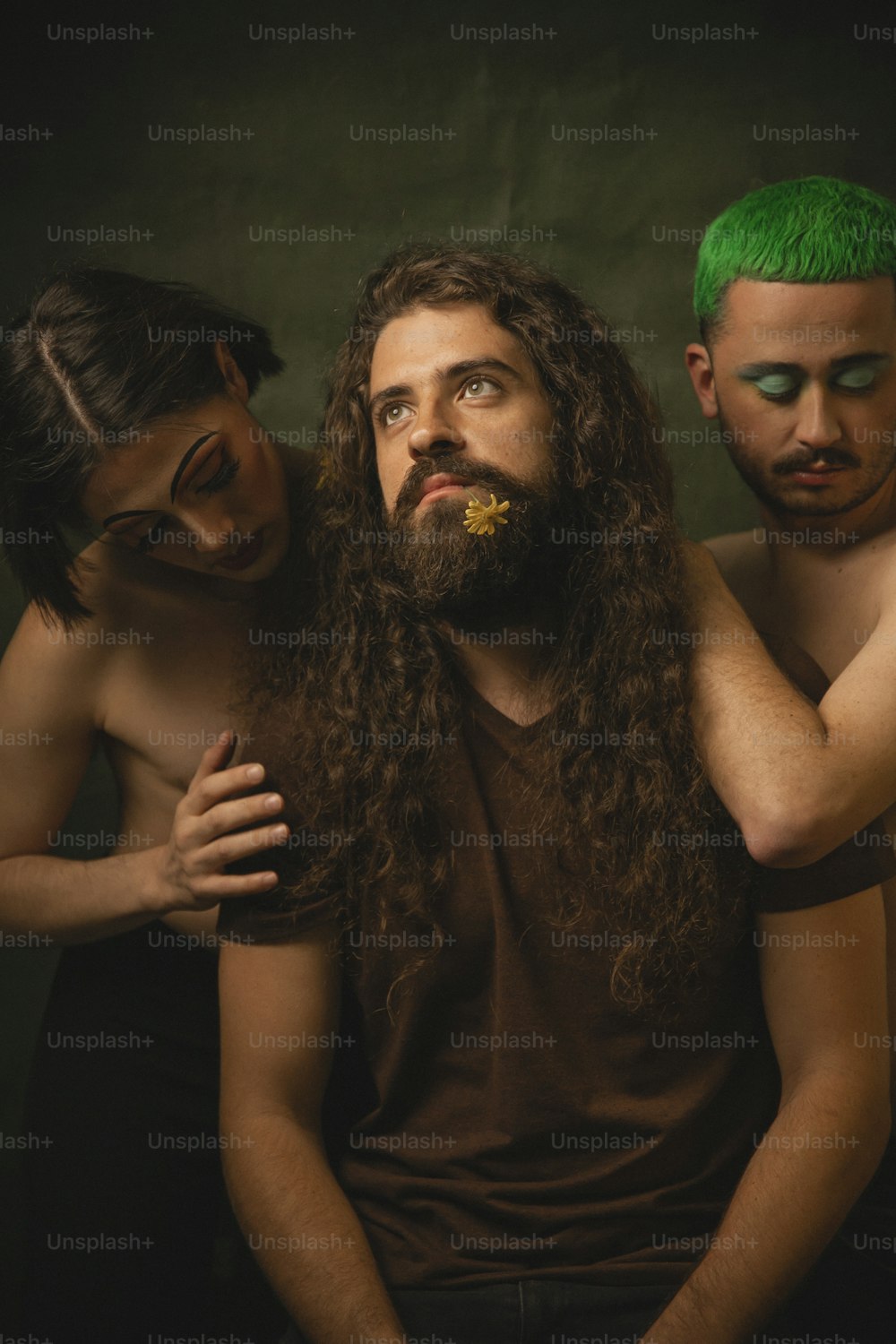 um homem com cabelos compridos e uma barba em pé ao lado de dois outros homens