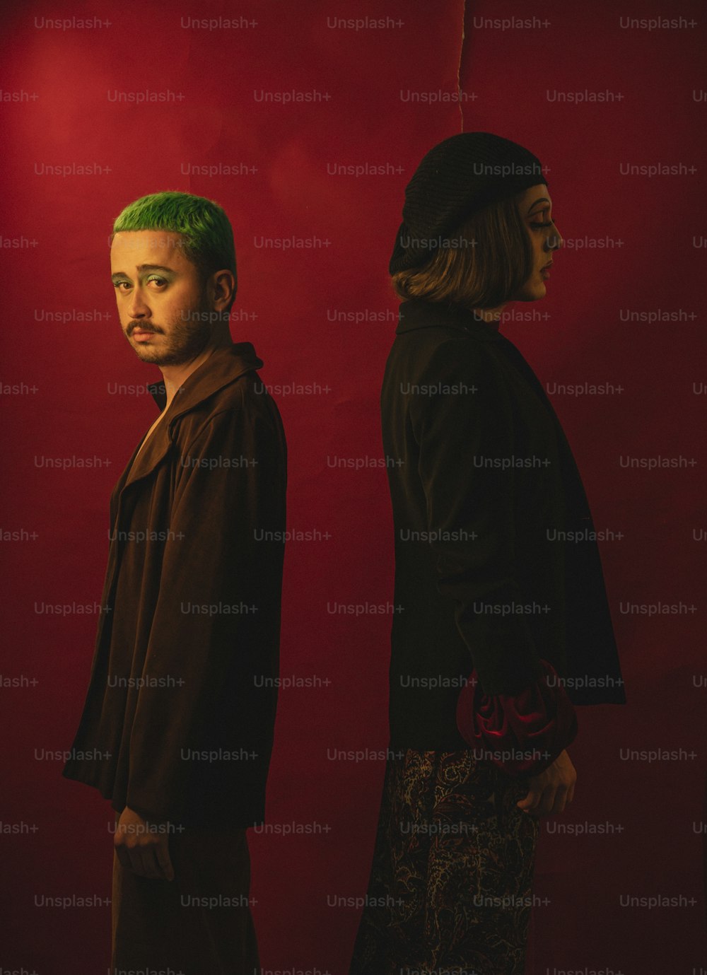 a man with green hair standing next to a woman