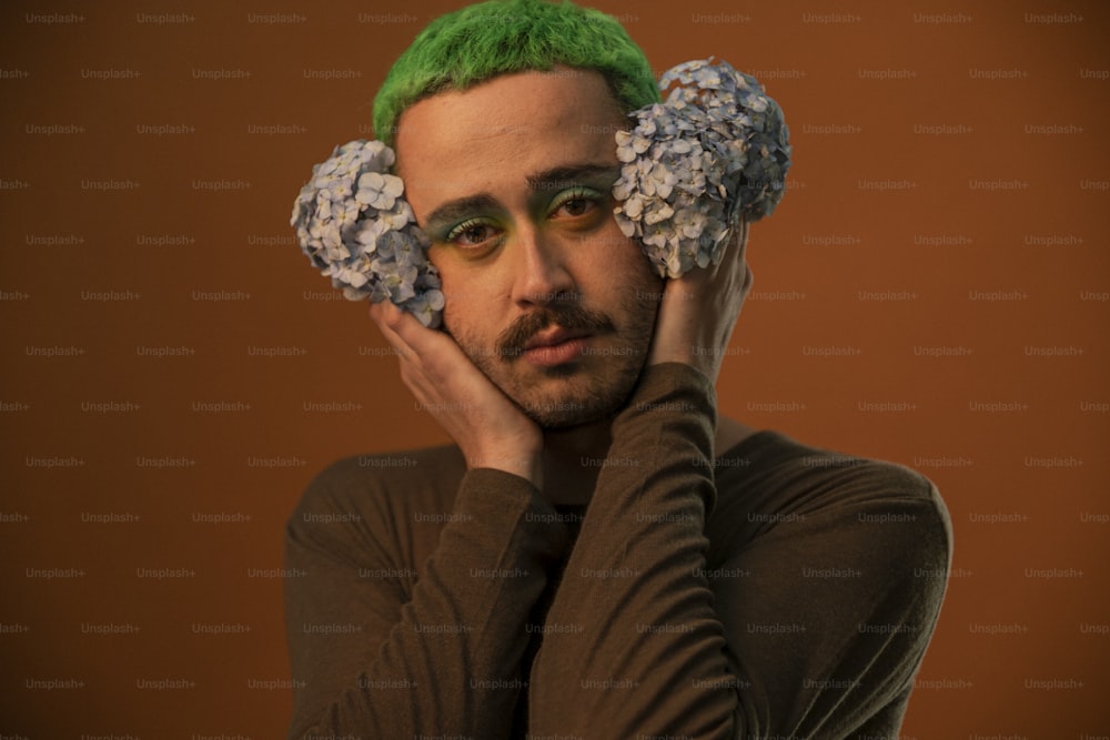 Un hombre con cabello verde y flores en el cabello