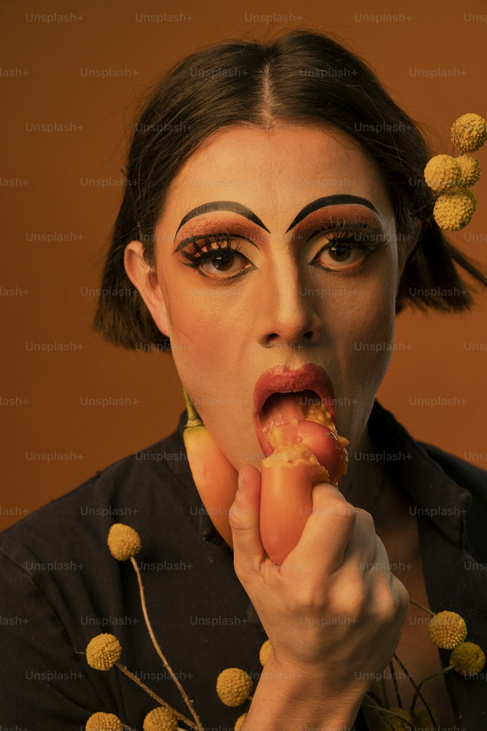 a woman with makeup on her face eating a piece of food