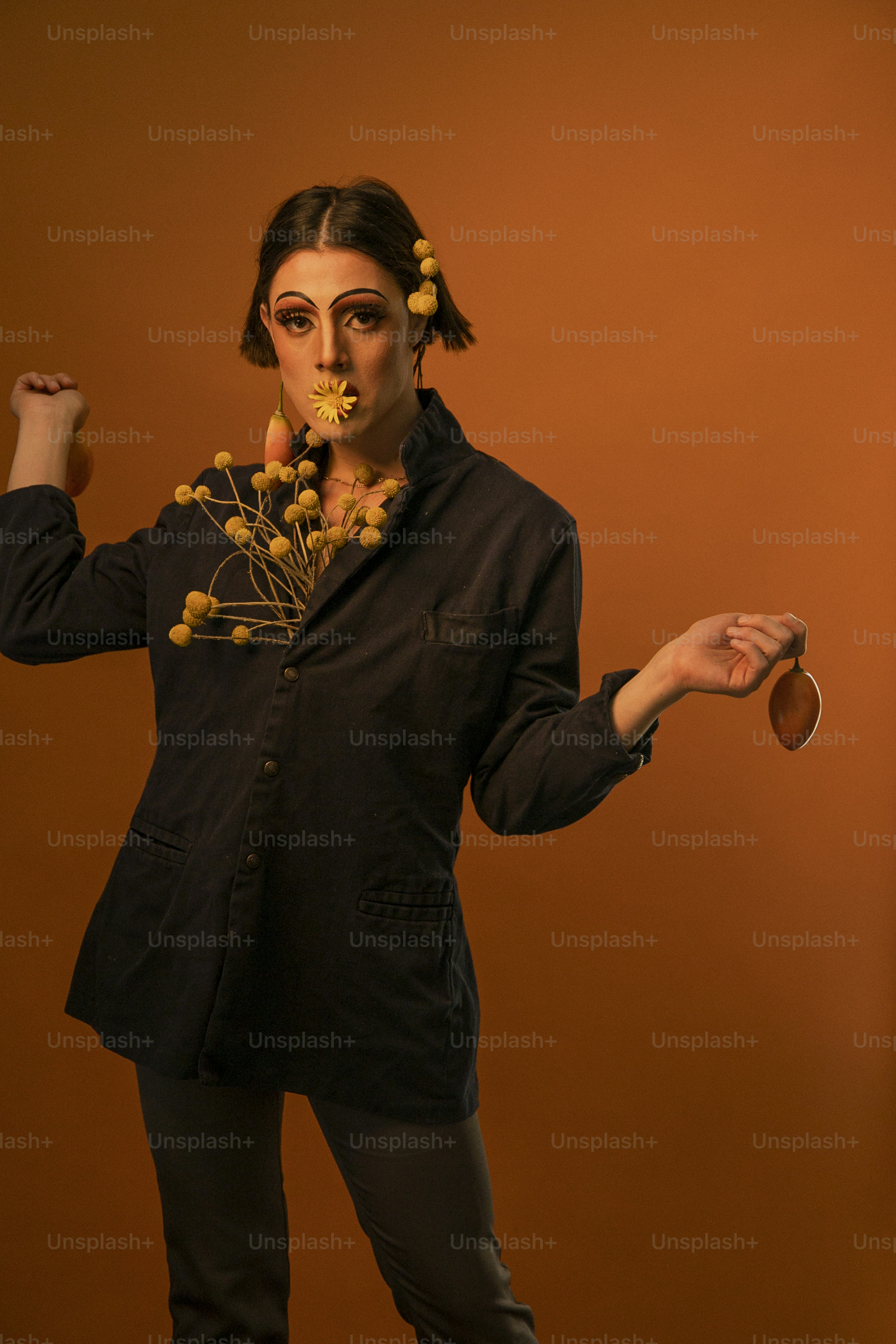 a woman in a black suit with flowers in her hair