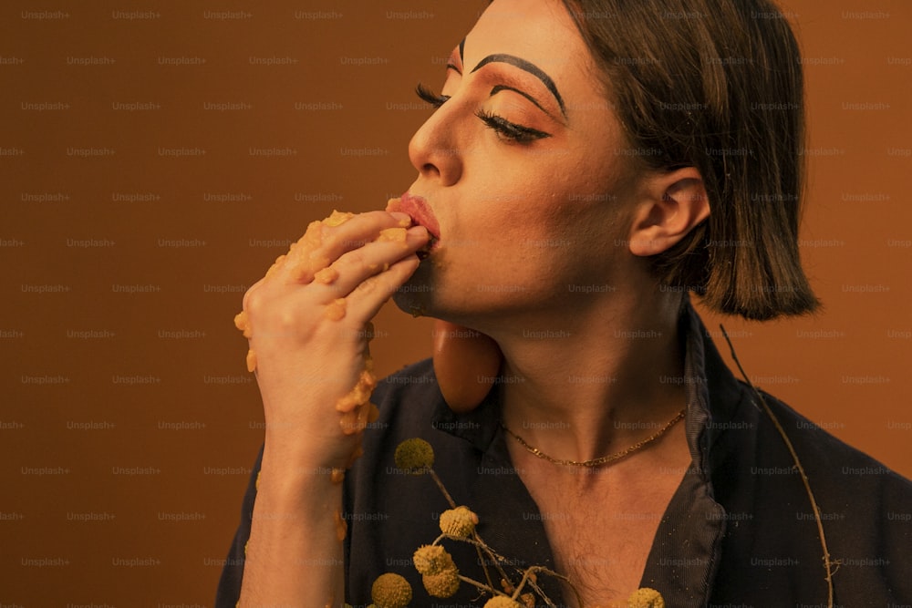 a woman with makeup on her face eating a donut
