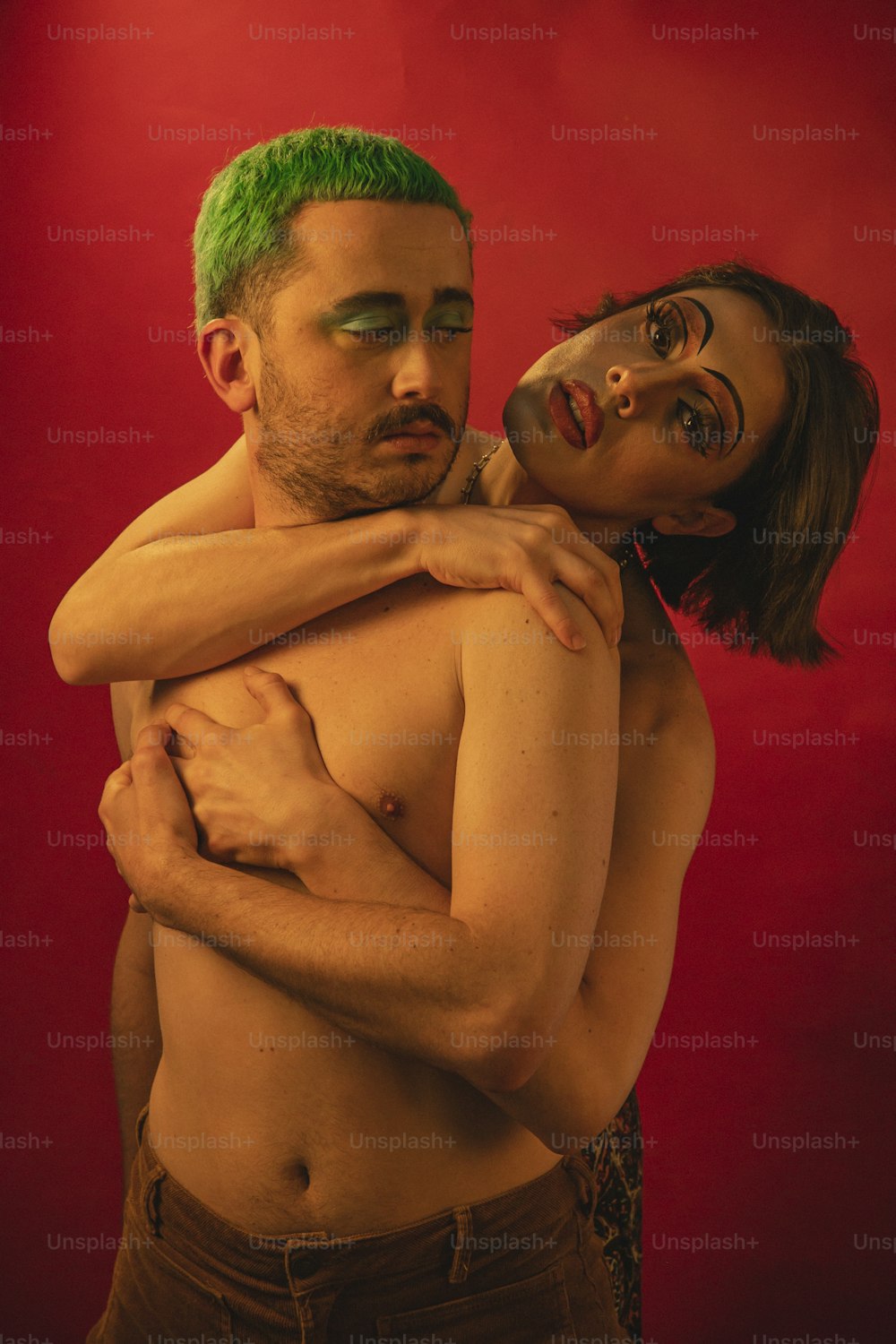 Un hombre con cabello verde abrazando a una mujer