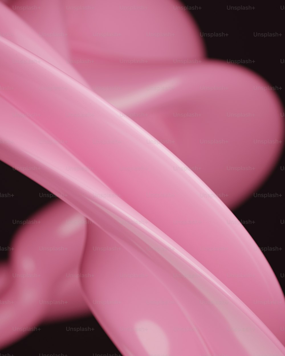 a close up of a pink object on a black background