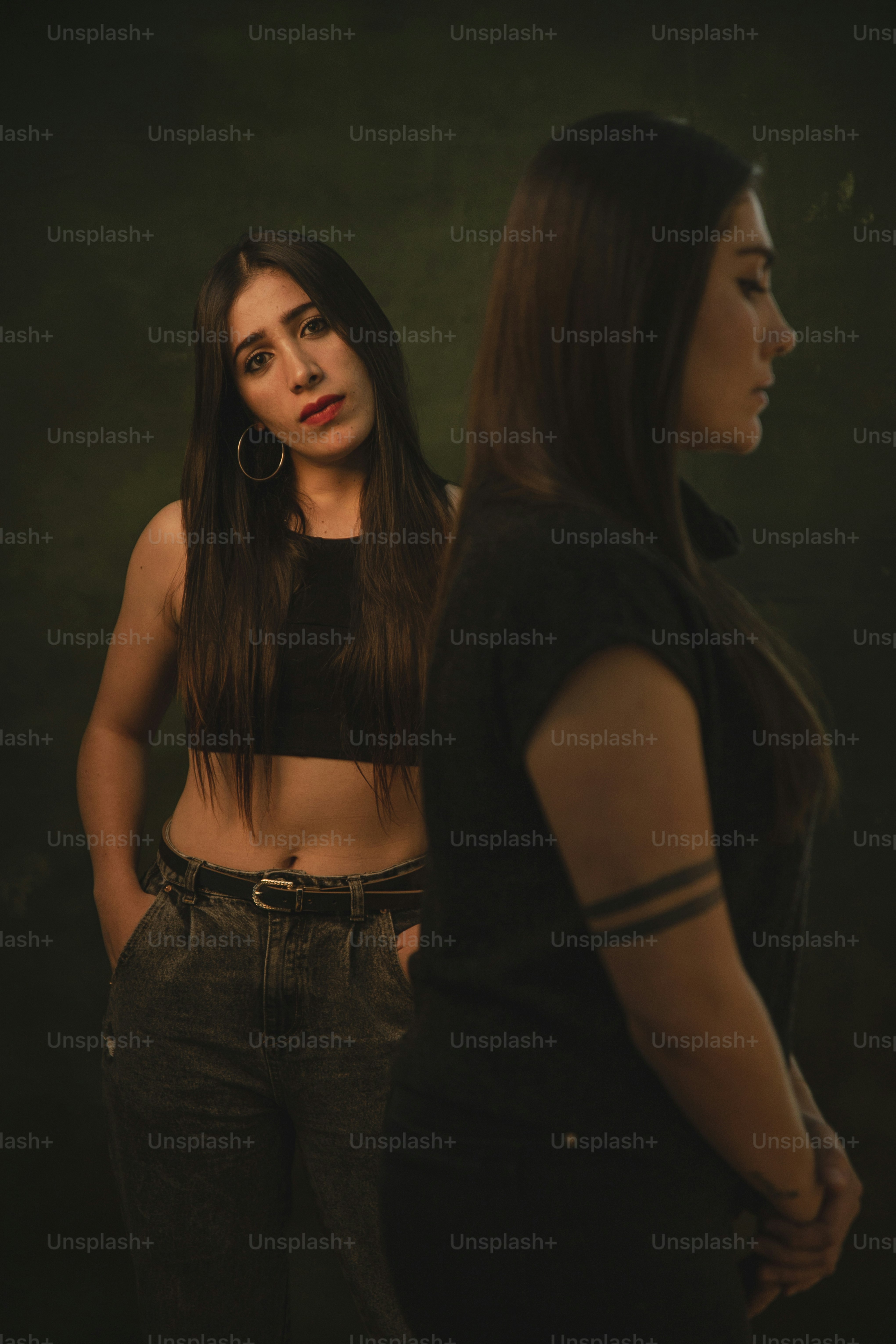 a woman standing next to another woman in a black top