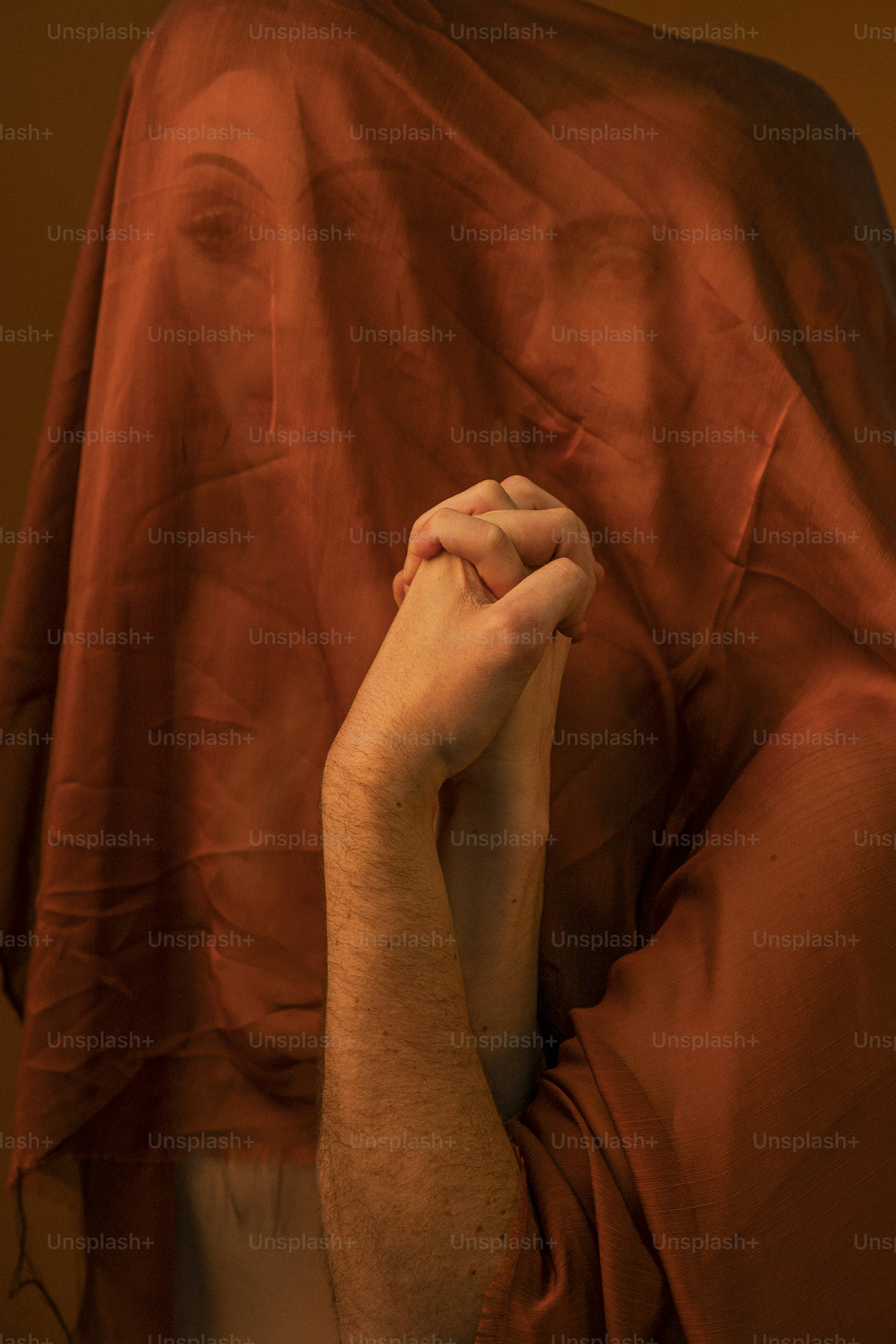 a man with a red shirt covering his face