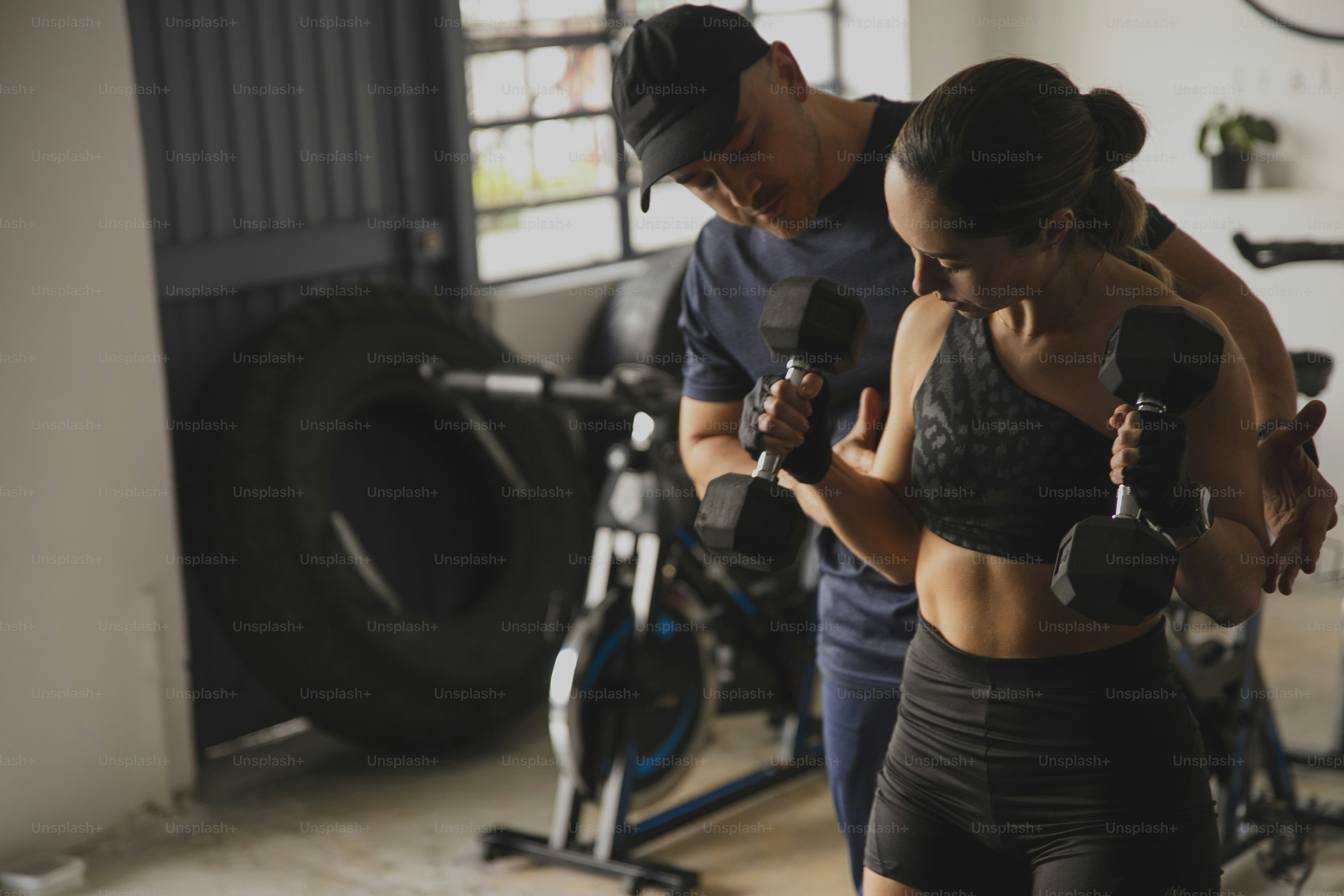 Un hombre y una mujer sosteniendo tontos en un gimnasio