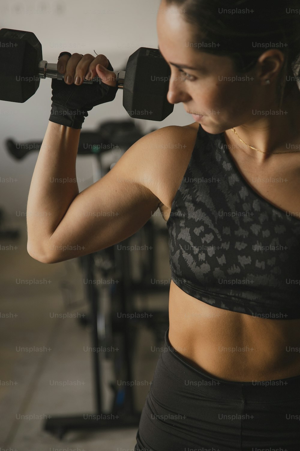 a woman lifting a dumbbell in a gym