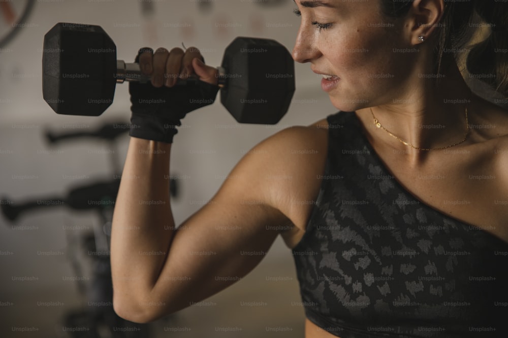 a woman lifting a pair of dumbbells in a gym