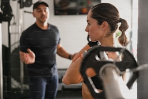 a man standing next to a woman in a gym