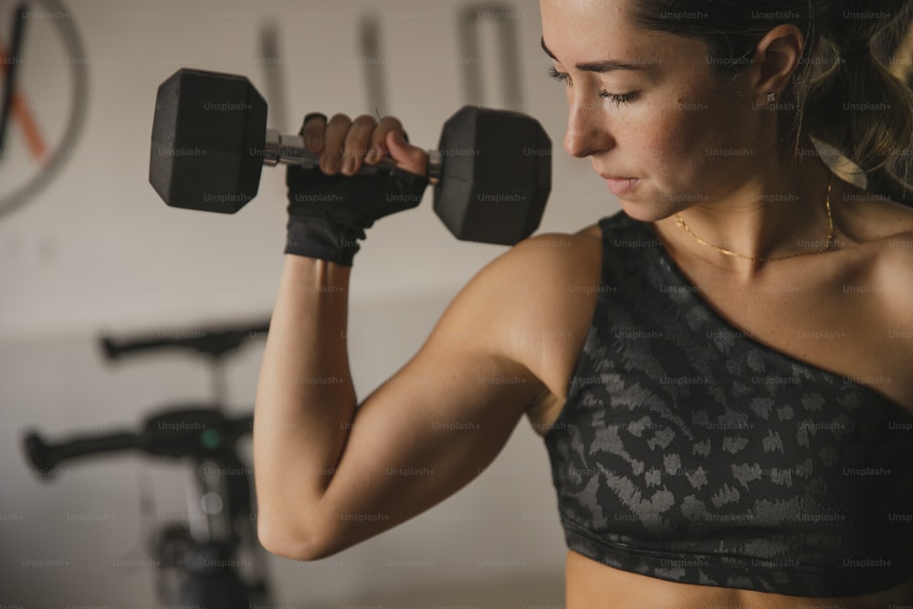 a woman lifting a pair of dumbbells in a gym