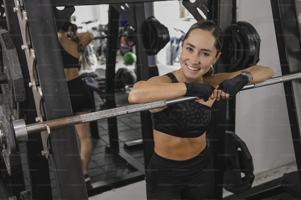 a woman in a gym holding a bar