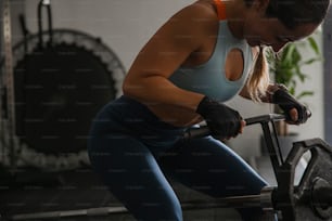 uma mulher que se exercita com uma barra em um ginásio