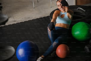 Una mujer sentada en el suelo junto a unas pelotas de ejercicio